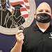 Jason Babin, director of the Office of Military and Veteran Services,  holds up a Stockton University challenge coin.