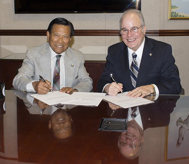 Cenon Jacob and President Harvey Kesselman sign gift agreement.
